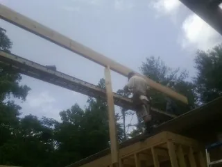 Carpenter setting a ridge beam over a new addition frame — Ice Dam Removal by Roofing Brothers in Chimayo