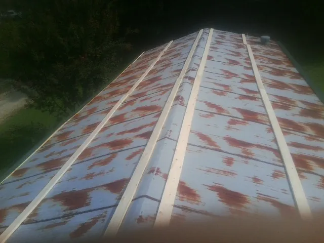 Rusted metal roof panels with new wood purlins before replacement — Storm Damage Roof Repair in Chimayo by Roofing Brothers