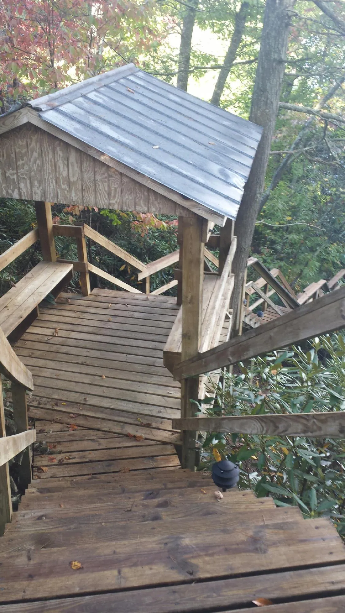 Metal roofed shelter over wooden steps on a wooded walkway — Skylight Repair & Installation work by our crew in Chimayo