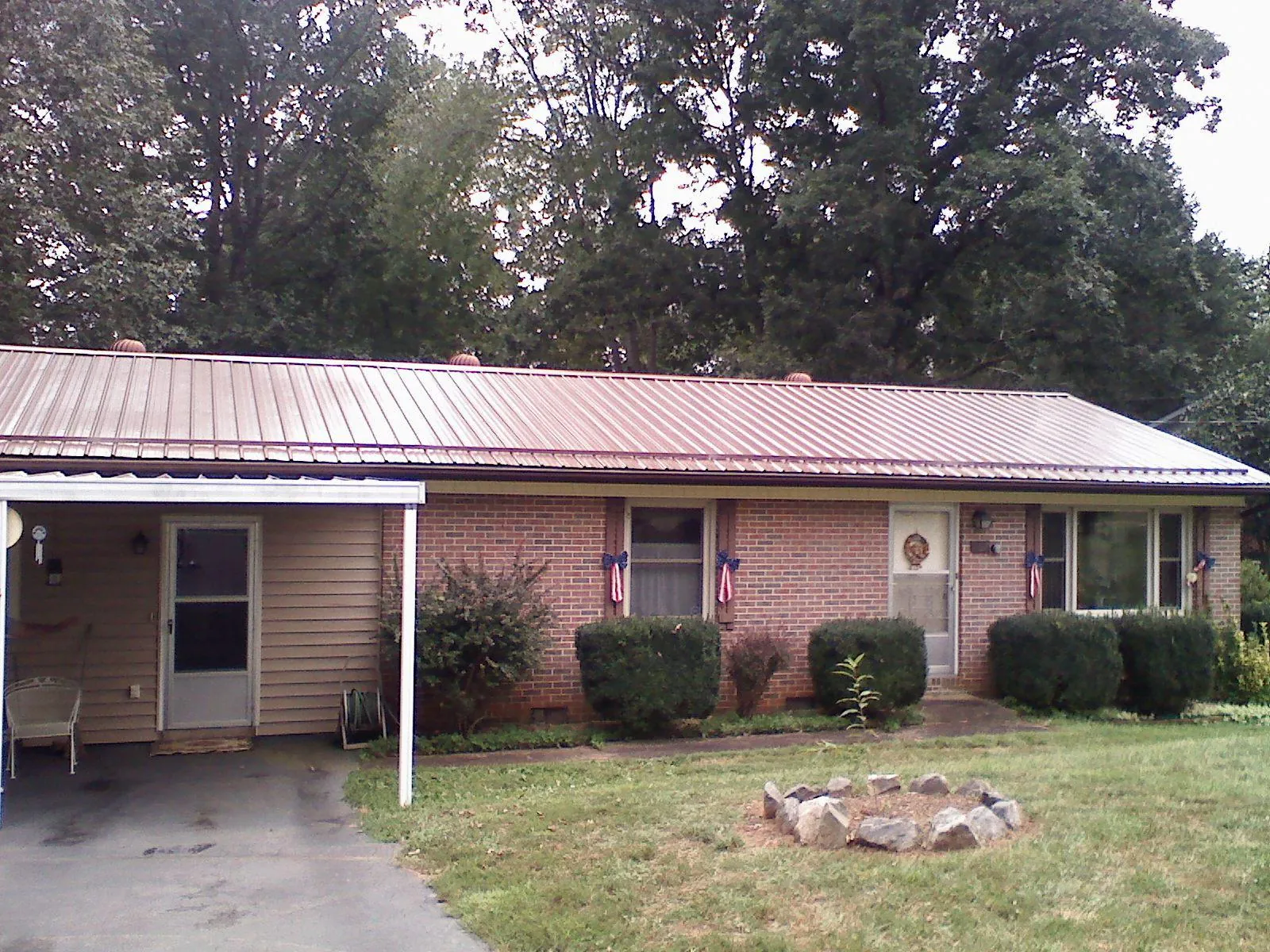 Bronze metal roof and carport on a brick ranch home — Roof Repair work by our crew in Chimayo